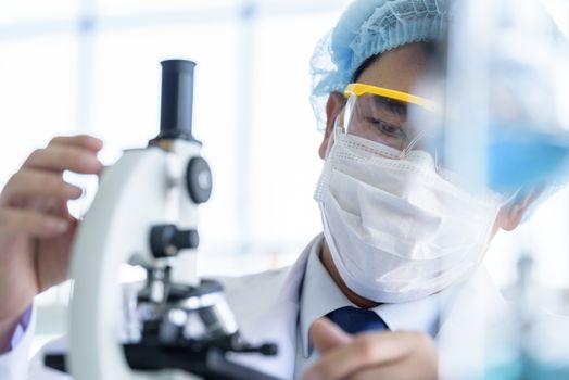 Asian young man student scientist researching  and learning in a laboratory.