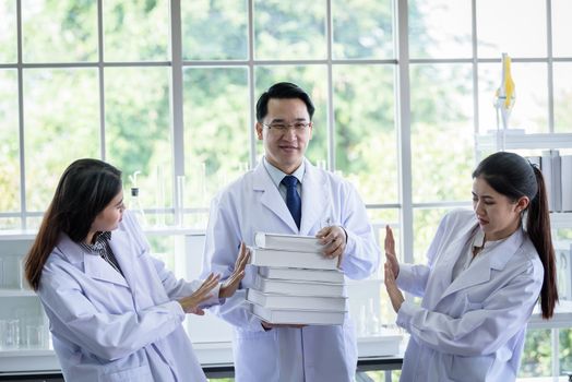 Senior asian scientist has assigning new job to students in laboratory.