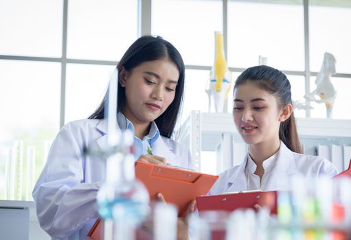 Asian young female working and research scientist together.