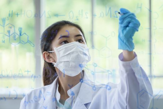 Asian young girl student scientist has writing and researching in laboratory.