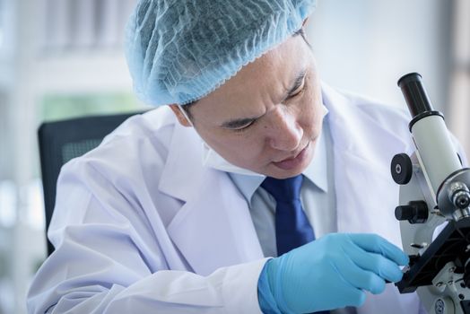 Asian man scientist researching  and learning in a laboratory.