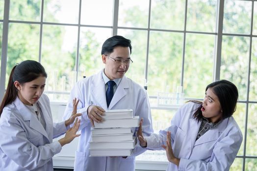 Senior asian scientist has assigning new job to students in laboratory.