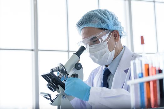 Asian man scientist researching  and learning in a laboratory.