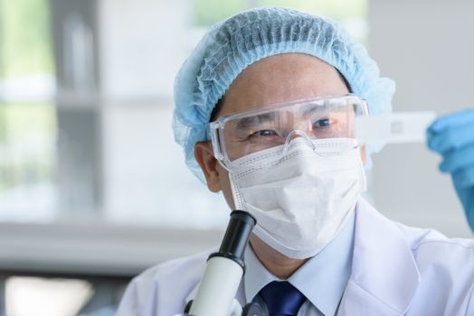 Asian man scientist researching  and learning in a laboratory.