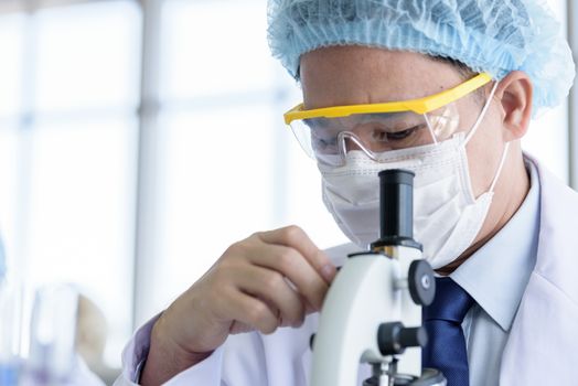 Asian young man student scientist researching  and learning in a laboratory.