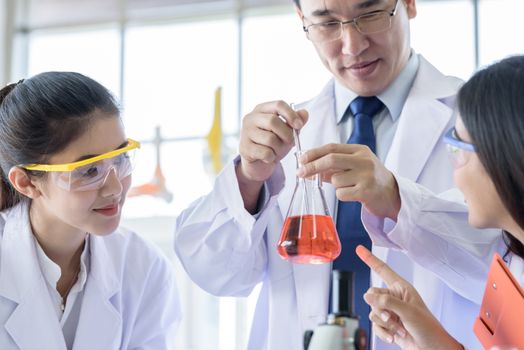 Asian yound student scientist researching  and learning with senior scientist have teaching background in a laboratory.