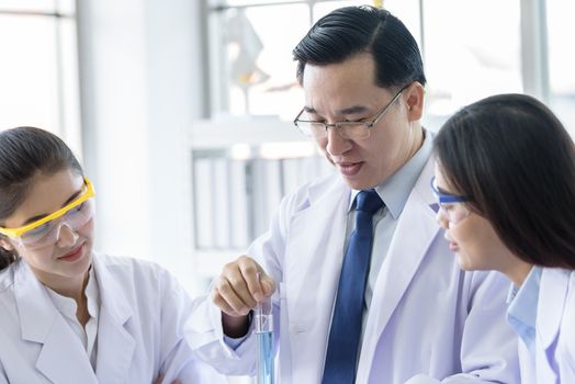 Asian senior laboratory scientist man working at lab with asian young student scientist backgroud.