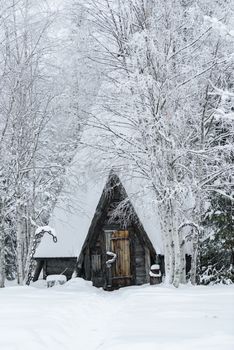 The house in the forest has covered with heavy snow and bad sky in winter season at Holiday Village Kuukiuru, Finland.
