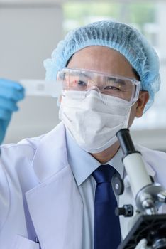 Asian man scientist researching  and learning in a laboratory.