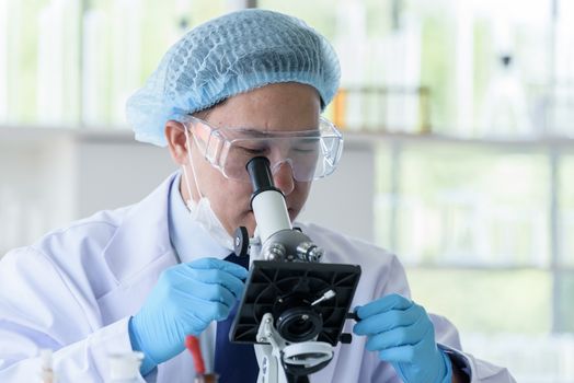 Asian man scientist researching  and learning in a laboratory.