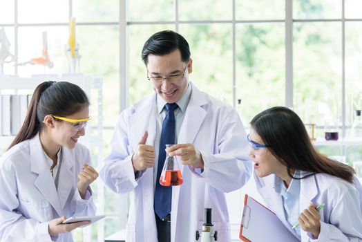 Asian senior scientist have teaching young student scientist in a laboratory.