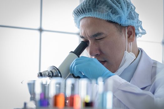 Asian man scientist researching  and learning in a laboratory.