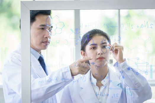 Asian scientist team has researching in laboratory.