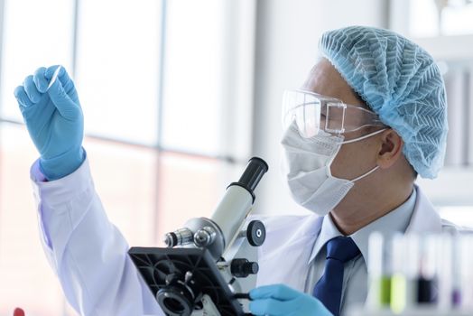 Asian man scientist researching  and learning in a laboratory.