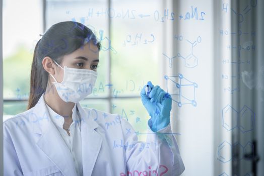 Asian young girl student scientist has writing and researching in laboratory.