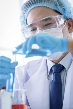 Asian man scientist researching  and learning in a laboratory.