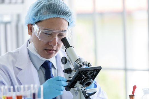 Asian man scientist researching  and learning in a laboratory.