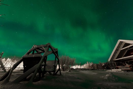 The northern lights Aurora Borealis at Kuukiuru village lake in Lapland, Finland.