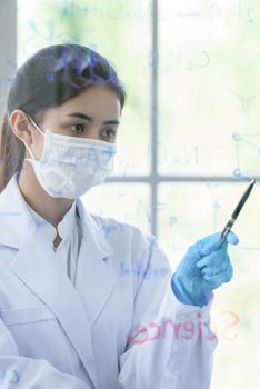 Asian young girl student scientist has writing and researching in laboratory.