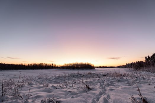 The ice lake and forest has covered with heavy snow and nice blue sky in winter season at Holiday Village Kuukiuru, Finland.