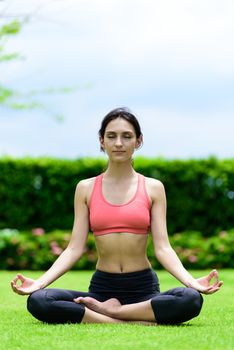 Beautiful woman runner has yoga meditation with peaceful and happy in the garden.