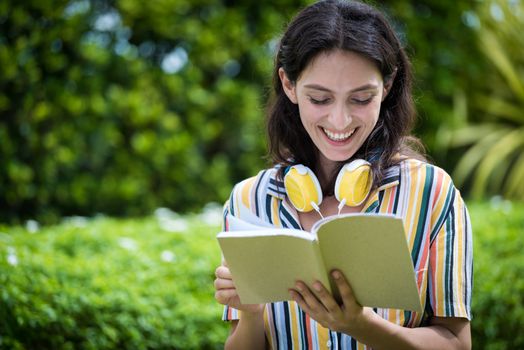 Portrait of a beautiful woman has reading a book with smiling and relax in the garden.