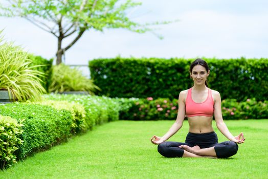 Beautiful woman runner has yoga meditation with peaceful and happy in the garden.