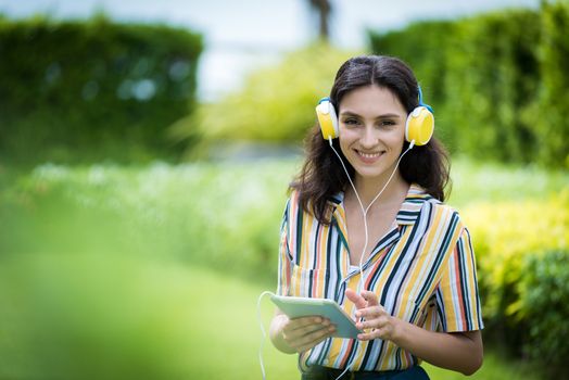 Portrait of a beautiful woman has listening to music with smiling and relax in the garden.