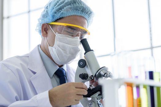 Asian young man student scientist researching  and learning in a laboratory.