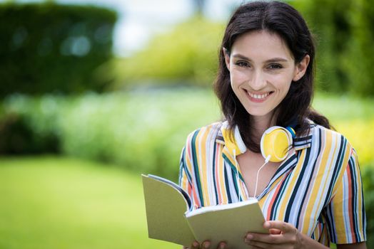 Portrait of a beautiful woman has reading a book with smiling and relax in the garden.