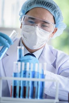 Asian man scientist researching  and learning in a laboratory.