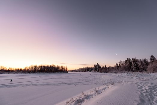 The ice lake and forest has covered with heavy snow and nice blue sky in winter season at Holiday Village Kuukiuru, Finland.