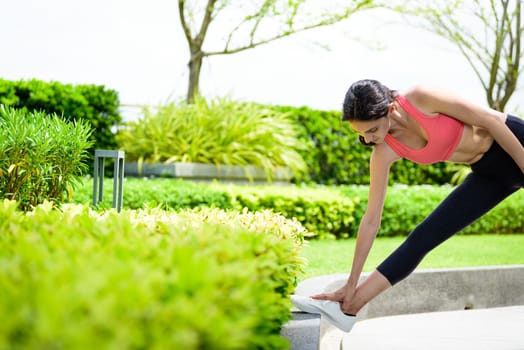 Beautiful woman runner has to warm up in the garden.