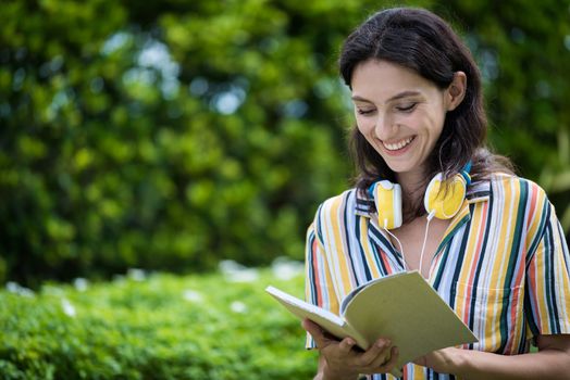 Portrait of a beautiful woman has reading a book with smiling and relax in the garden.