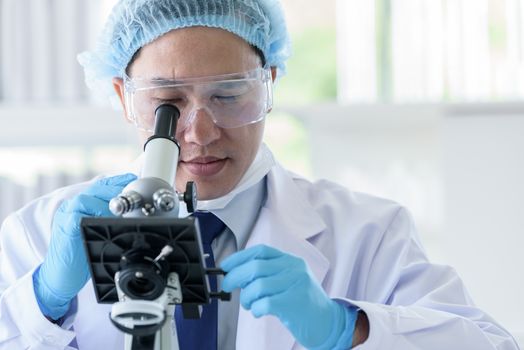 Asian man scientist researching  and learning in a laboratory.