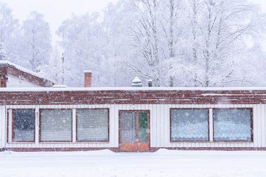 The house in the forest has covered with heavy snow and bad sky in winter season at Lapland, Finland.