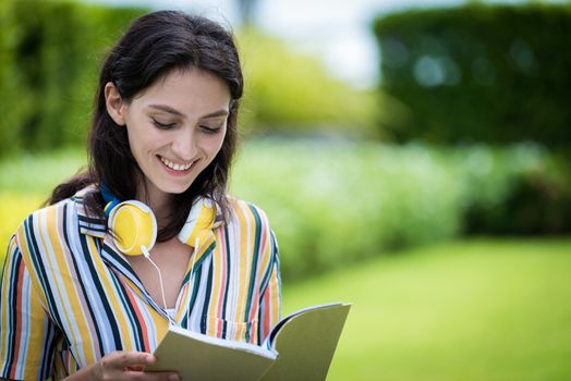 Portrait of a beautiful woman has reading a book with smiling and relax in the garden.