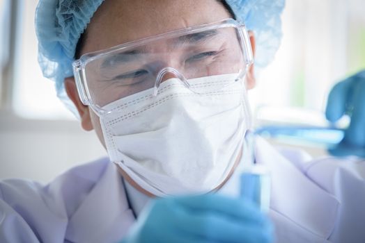 Asian man scientist researching  and learning in a laboratory.