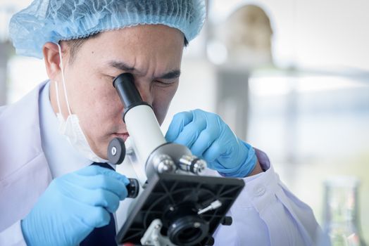 Asian man scientist researching  and learning in a laboratory.