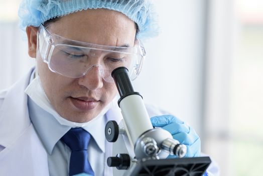 Asian man scientist researching  and learning in a laboratory.