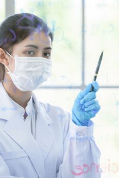 Asian young girl student scientist has writing and researching in laboratory.