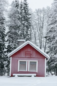 The house in the forest has covered with heavy snow and bad sky in winter season at Holiday Village Kuukiuru, Finland.