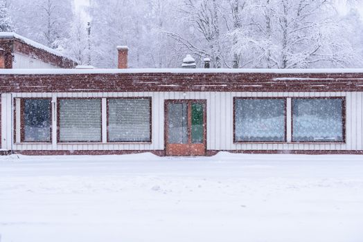 The house in the forest has covered with heavy snow and bad sky in winter season at Lapland, Finland.