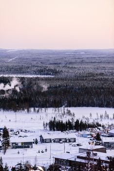 The village in the forest has covered with heavy snow and sunset sky from top view landscape in winter season at Lapland, Finland.
