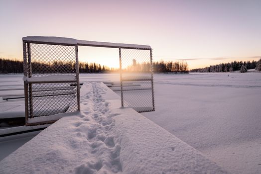 The ice lake and forest has covered with heavy snow and nice blue sky in winter season at Holiday Village Kuukiuru, Finland.