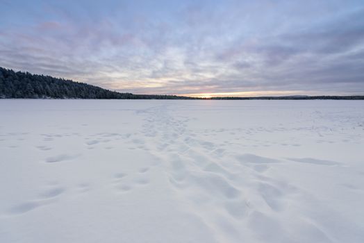 The ice lake has covered with heavy snow and sky in winter season at Oulanka National Park, Finland.