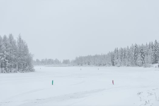 The ice lake and forest has covered with heavy snow and bad weather sky in winter season at Holiday Village Kuukiuru, Finland.