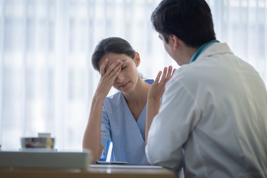 A doctor takes care of a sick patient woman with sadness and unhappiness at the hospital or medical clinic.