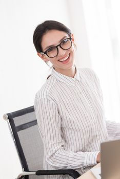 A businesswoman wearing glasses working with smiling and happiness at the office.