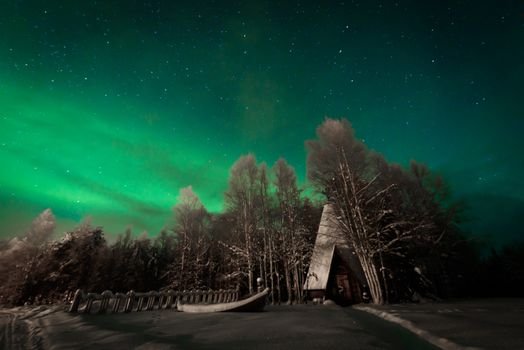 The northern lights Aurora Borealis at Kuukiuru village lake in Lapland, Finland.